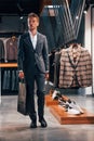 Walks with bag in hand. Young guy in modern store with new clothes. Elegant expensive wear for men