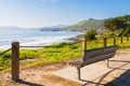 Walkway along the shore and wooden bench overlooking the ocean, California