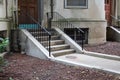 Walkway and concrete steps entryway to a brownstone apartment building with wrought iron railings Royalty Free Stock Photo