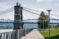 Walkway and the John A. Roebling Suspension Bridge, seen at Smale Riverfront Park, in Cincinnati, Ohio