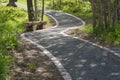 A walkway in a park with a wooden bench at the side Royalty Free Stock Photo