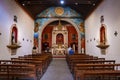 Walkway between wooden pews leading towards crucifix in church