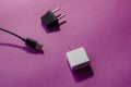 Wall adapters for U.S. and Europe and USB data cable in pink background Royalty Free Stock Photo