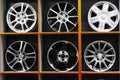 Wall of alloy car wheels and pneumatic tires in store. seasonal wheel storage Royalty Free Stock Photo