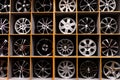 Wall of alloy car wheels and pneumatic tires in store. seasonal wheel storage Royalty Free Stock Photo