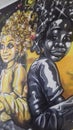 Wall art graffiti of 2 Afro caribbean people 1 Black the other yellow.