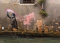 Wall with Banksy art by a canal in Venice, Italy