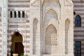 A wall with a beautiful texture of a Muslim Islamic Arab mosque made of white brick architecture with arches, tall towers, domes a Royalty Free Stock Photo