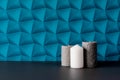 A wall with blue patterned wallpaper. Three candles, one white, the rest gray Royalty Free Stock Photo