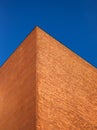 A wall of brick against a blue sky. Abstract shapes of buildings in the city. Design and architecture. Royalty Free Stock Photo