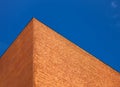 A wall of brick against a blue sky. Abstract shapes of buildings in the city. Design and architecture. Royalty Free Stock Photo