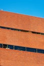 Wall of brick with orange color in the downtown city with some visible windows in a horizontal row Royalty Free Stock Photo