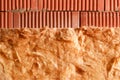 Wall of bricks and insulation wool. Building with cavity wall insulation. Close up. Royalty Free Stock Photo