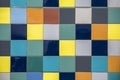 Wall of bright multi-colored yellow, blue, white, gray square ceramic tiles. rough surface texture Royalty Free Stock Photo