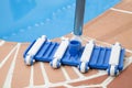 Wall Brush and Leaf Skimmer Maintenance Tools on Deck Beside Swimming Pool Royalty Free Stock Photo