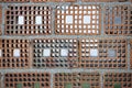 Wall built of perforated bricks. The holes are plastered with square and concrete. Pattern