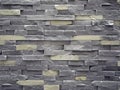 Wall cladding made of cement artificial stone slabs. Colors are gray and pale yellow