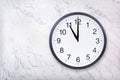 Wall clock show eleven o`clock on white marble texture. Office clock show 11pm or 11am