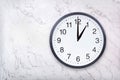 Wall clock show one o`clock on white marble texture. Office clock show 1pm or 1am