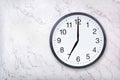 Wall clock show seven o`clock on white marble texture. Office clock show 7pm or 7am
