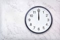 Wall clock show the twelve o`clock on white marble texture. Office clock show midday or midnight Royalty Free Stock Photo