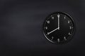 Wall clock showing eight o`clock on black chalkboard background. Office clock showing 8am or 8pm on black texture