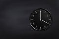 Wall clock showing four o`clock on black chalkboard background. Office clock showing 4am or 4pm on black texture Royalty Free Stock Photo