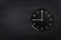 Wall clock showing nine o`clock on black chalkboard background. Office clock showing 9am or 9pm on black texture