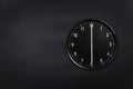 Wall clock showing six o`clock on black chalkboard background. Office clock showing 6am or 6pm on black texture