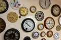 Wall of clocks with different shapes, colors, and times