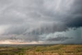 A wall cloud gathers under the base of a supercell storm in the prairie. Royalty Free Stock Photo