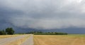 Wall cloud of a thunderstorm above dry yellow fields and green trees in Laag Zuthem in Overijssel, the Netherlands. Royalty Free Stock Photo