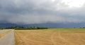 wall cloud of a thunderstorm above dry yellow fields and green trees in Laag Zuthem in Overijssel, the Netherlands. Royalty Free Stock Photo