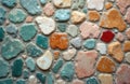 Wall covered with multicolor irregular tiles and stone chips. Small rough blocks form art textured surface. Light grey cement Royalty Free Stock Photo