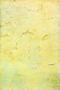 Wall with cracked bright yellow paint. Bright background with vignette. Texture of old cover with cracks. Royalty Free Stock Photo