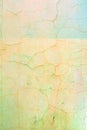 Wall with cracked pale yellow and green paint. Bright background with vignette. Texture of old cover with cracks. Royalty Free Stock Photo