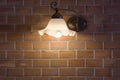 Wall desk lamp shining on brick stone wall. Royalty Free Stock Photo