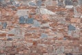 The wall of different colored natural stones forms a mosaic and a background