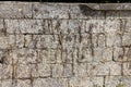 A wall of even stone blocks with the remains of last year's dry grass, stone background Royalty Free Stock Photo