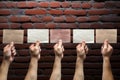 Wall of expression five male hands with blank signs, brick background