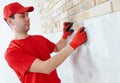 Wall facing work with brick by professional bricklayer worker