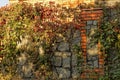 A wall of a fence made of gray stones and brown bricks Royalty Free Stock Photo