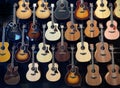 a wall full of acoustic guitars of different models and types of wood, guitars store Royalty Free Stock Photo