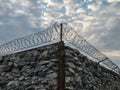 A wall of grey stone topped with barbed wire. Royalty Free Stock Photo