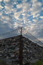 A wall of grey stone topped with barbed wire. Royalty Free Stock Photo