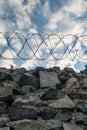 A wall of grey stone topped with barbed wire. Royalty Free Stock Photo