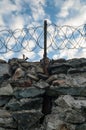A wall of grey stone topped with barbed wire. Royalty Free Stock Photo