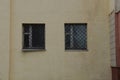 wall of the house with two gray windows with bars Royalty Free Stock Photo