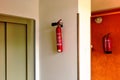 wall hung fire extinguishers in common area of apartment building. red cylinders. fire and life safety Royalty Free Stock Photo