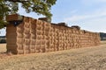 A wall of large stacked hay bales